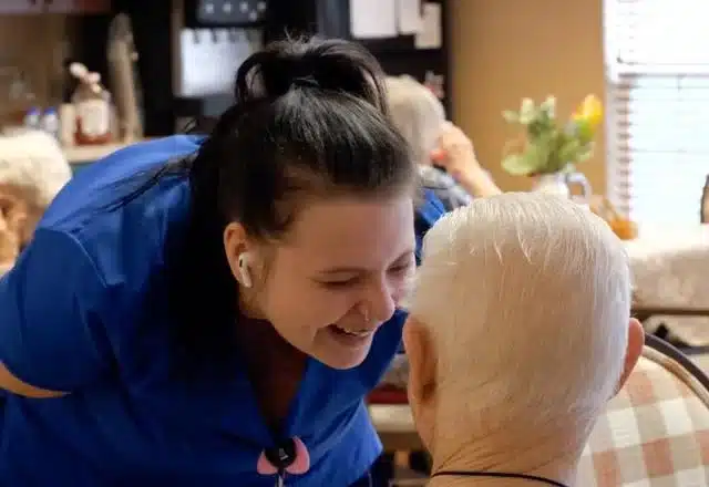 Morning Pointe of Franklin CNA Kourtney Cox laughs while helping a resident with his dinner. (Photo/Ashlyn Myers of TheStatehouseFile.com)