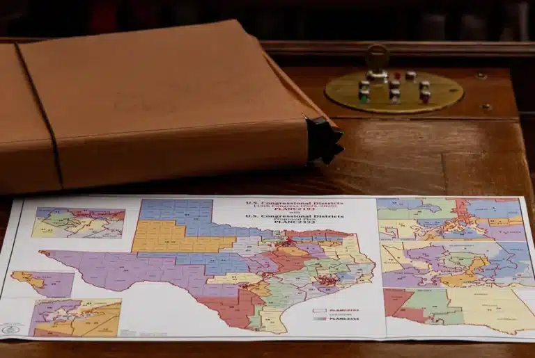 A map of the proposed changes to Texas congressional districts sits on a Texas House member’s desk on Aug. 20, 2025. (Photo/Kaylee Greenlee for The Texas Tribune)