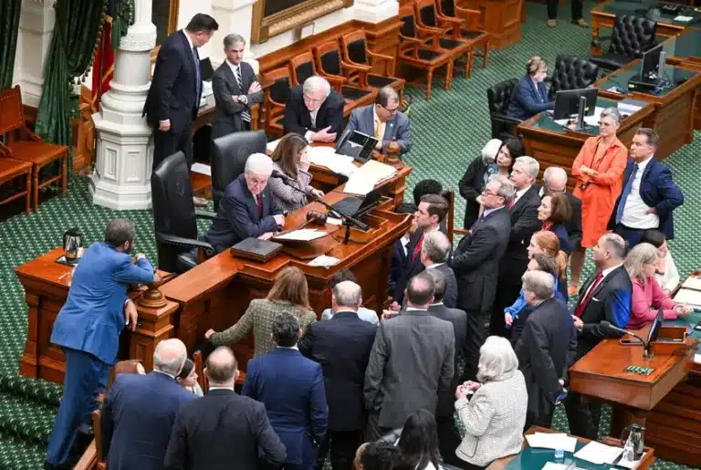 Texas state lawmakers gather around Lt. Gov. Dan Patrick’s desk before the final vote on the mid-decade redistricting bill in the Texas Senate. (Photo/Bob Daemmrich for The Texas Tribune)