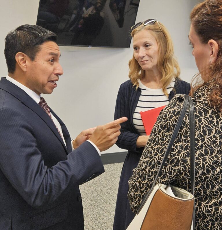 Indiana Secretary of State Diego Morales spoke with circuit court clerks Amy Thompson, of Jennings County (holding red folder), and Michelle Shelton, of Scott County, after the election study meeting in Jeffersonville on Sept. 19. (Photo/Marilyn Odendahl)