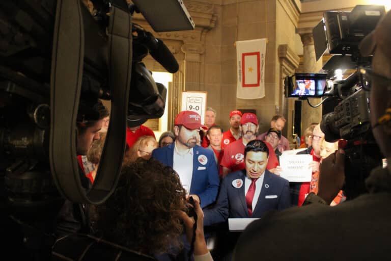 Lt. Gov. Micah Beckwith, left in red hat, along with Indiana Secretary of State Diego Morales, held a pro-redistricting rally on Organization Day to keep the pressure on state lawmakers. (Photo/Sydney Byerly