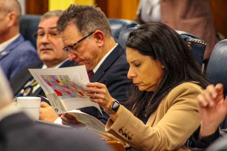 Sen. Cyndi Carrasco, R-Indianapolis, and other Republican lawmakers examined the proposed map during the Senate debate on redistricting. (Photo/Sydney Byerly)